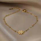 SVORA gold plated stainless steel daisy chain bracelet with a clear cubic zirconia stone. Adjustable lobster clasp.