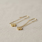 SVORA gold thread-through earrings with pavé cubic zirconia clover charms. Delicate chain design.