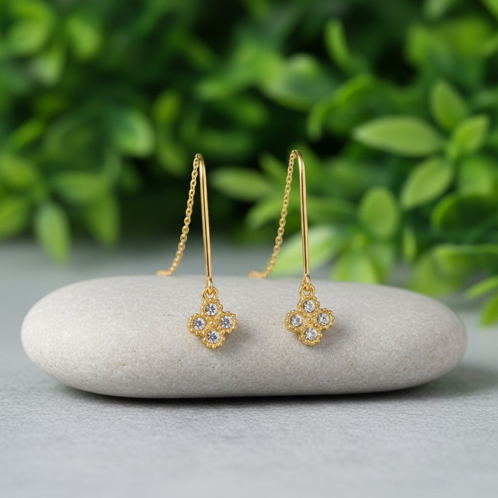 SVORA gold thread-through earrings with pavé cubic zirconia clover charms and delicate chains.