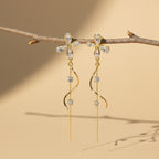 Pair of gold and crystal earrings on a twig