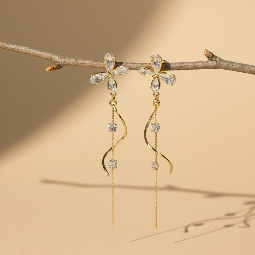 Pair of gold and crystal earrings on a twig