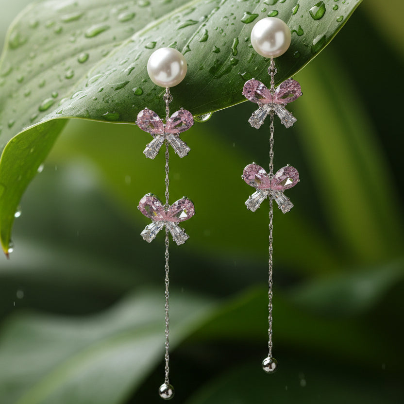 Pair of earrings with bow-shaped charms on a dark background