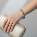 SVORA amethyst and peach champagne CZ halo tennis bracelet with princess-cut links set in silver. Rhodium plated, waterproof.