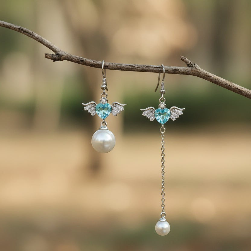 SVORA asymmetric earrings with aqua heart, wings, and pearl drop. Silver-tone.