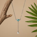 SVORA silver-tone necklace with aqua heart pendant, wings, and pearl drop. Asymmetric design.