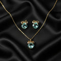SVORA gold-tone necklace and earrings set with aqua cushion-cut crystals and pavé bow details.