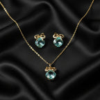 SVORA gold-tone necklace and earrings set with aqua cushion-cut crystals and pavé bow details.