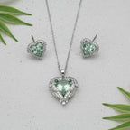 SVORA aqua heart necklace and earrings set with pavé wings and crown detail, made of stainless steel and cubic zirconia.