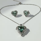 SVORA aqua heart necklace and earrings set with silver-tone pavé wings and crown detail. Features aqua crystal cubic zirconia.