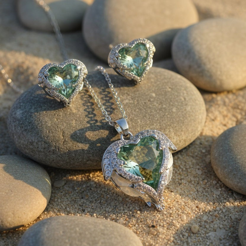 SVORA aqua heart necklace and earrings set with pavé wings and crown detail, made of stainless steel and cubic zirconia.