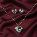 SVORA aqua heart necklace and earrings set with silver-tone pavé wings and crown detail. Features aqua crystal cubic zirconia.
