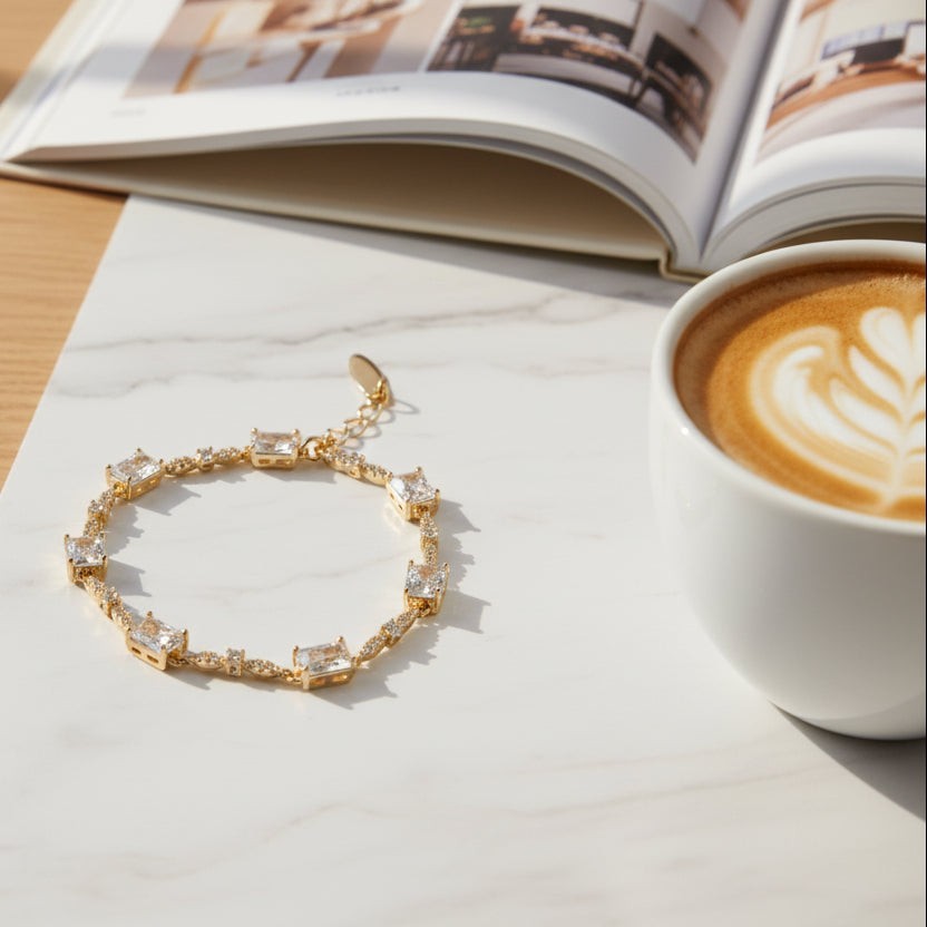 SVORA gold plated stainless steel baguette tennis bracelet with emerald-cut CZ stones and round accents.