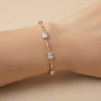 SVORA gold plated tennis bracelet with emerald-cut CZ baguettes and round stones on a wrist.