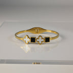 SVORA gold plated stainless steel bracelet with alternating white clover and black square charms.
