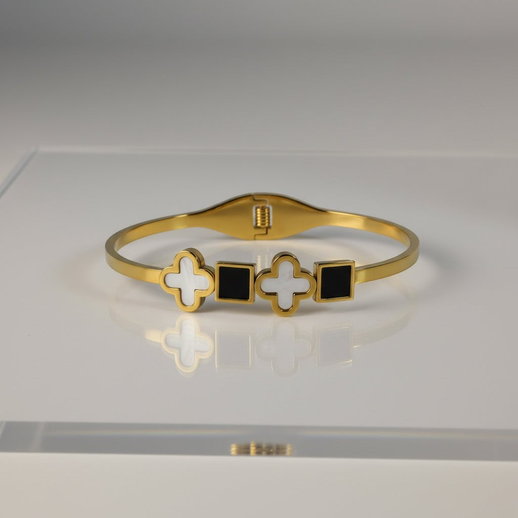 SVORA gold plated stainless steel bracelet with alternating white clover and black square charms.