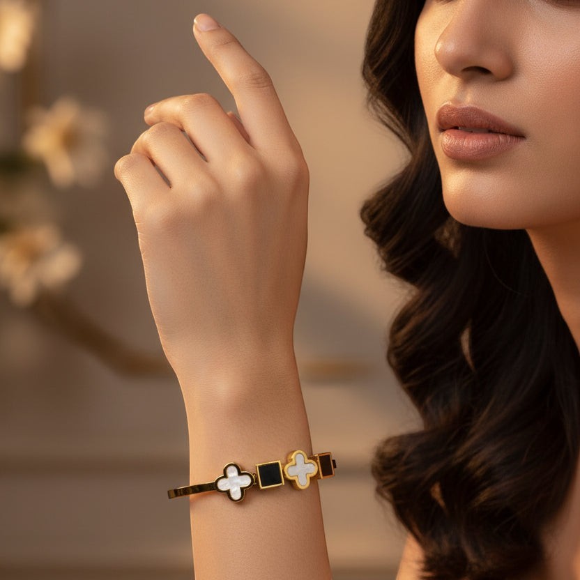 SVORA black onyx and white mother-of-pearl clover and square charm bracelet on gold band.