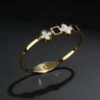 SVORA gold-plated stainless steel bracelet with alternating black onyx squares and white mother-of-pearl clover motifs.