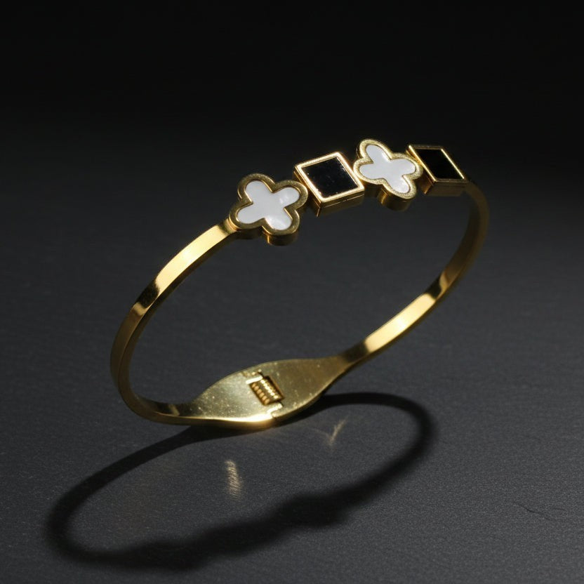 SVORA gold-plated stainless steel bracelet with alternating black onyx squares and white mother-of-pearl clover motifs.