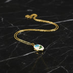 SVORA gold plated stainless steel oval locket necklace with blue rose and green leaf enamel detail.