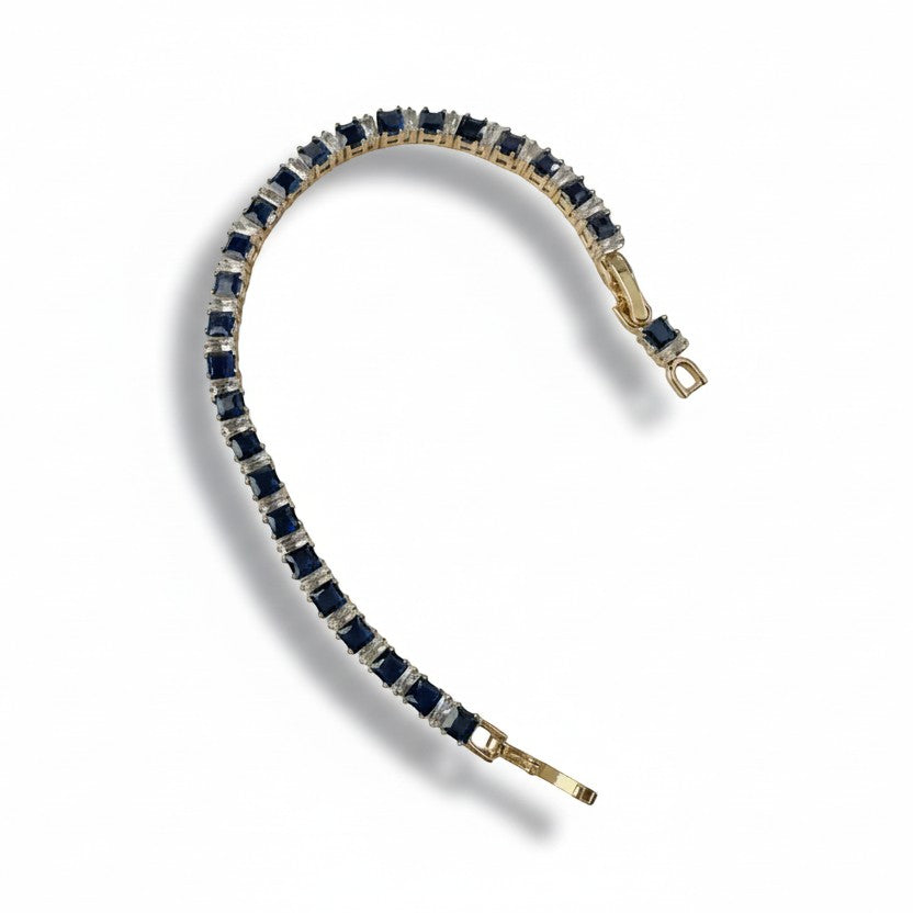 SVORA 18k gold-plated stainless steel tennis bracelet with alternating square-cut blue sapphires and clear stones.