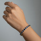 SVORA 18k gold-plated stainless steel tennis bracelet with blue sapphire and diamond accents.