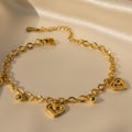 SVORA gold cable chain bracelet with three heart charms and gold beads. 18K gold plated stainless steel.
