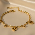 SVORA gold cable chain bracelet with three heart charms and gold beads. 18K gold plated stainless steel.