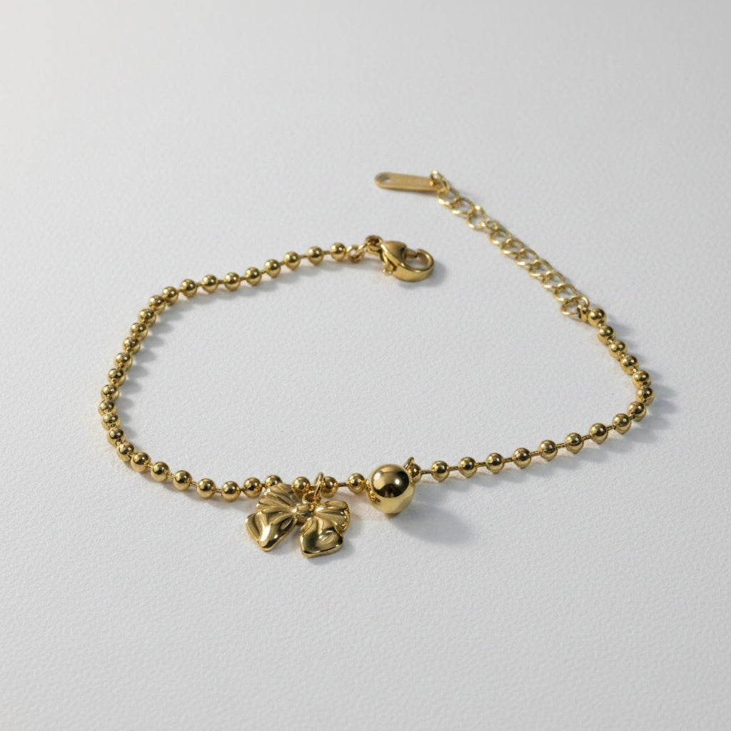 SVORA gold-plated stainless steel bracelet with a bow charm and ball bead chain. Adjustable with lobster clasp.