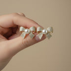 SVORA gold-tone bow stud earrings with pearl center and pavé crystal details