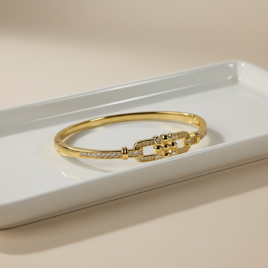 SVORA gold-plated stainless steel bangle bracelet with buckle cluster and CZ stones.