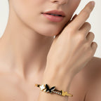 SVORA gold-plated stainless steel bracelet with black onyx butterfly, white pearl clover, and small gold butterfly.