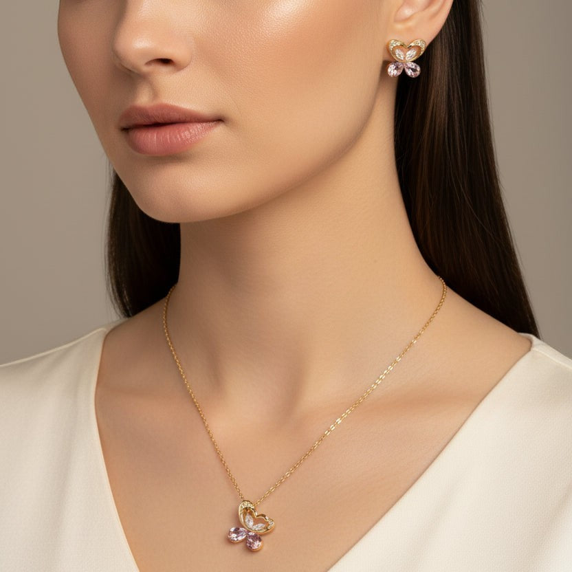 SVORA gold tone butterfly necklace and earrings set with pink crystals and cubic zirconia. Stainless steel.