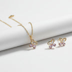 SVORA gold tone necklace and earrings set with butterfly pendants, cubic zirconia, and pink crystals.