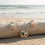 SVORA gold tone necklace and earrings set with pink, green, and cream cabochon stones in a caged design.