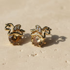 SVORA champagne crystal solitaire stud earrings with gold apple silhouette and small cubic zirconia accents.
