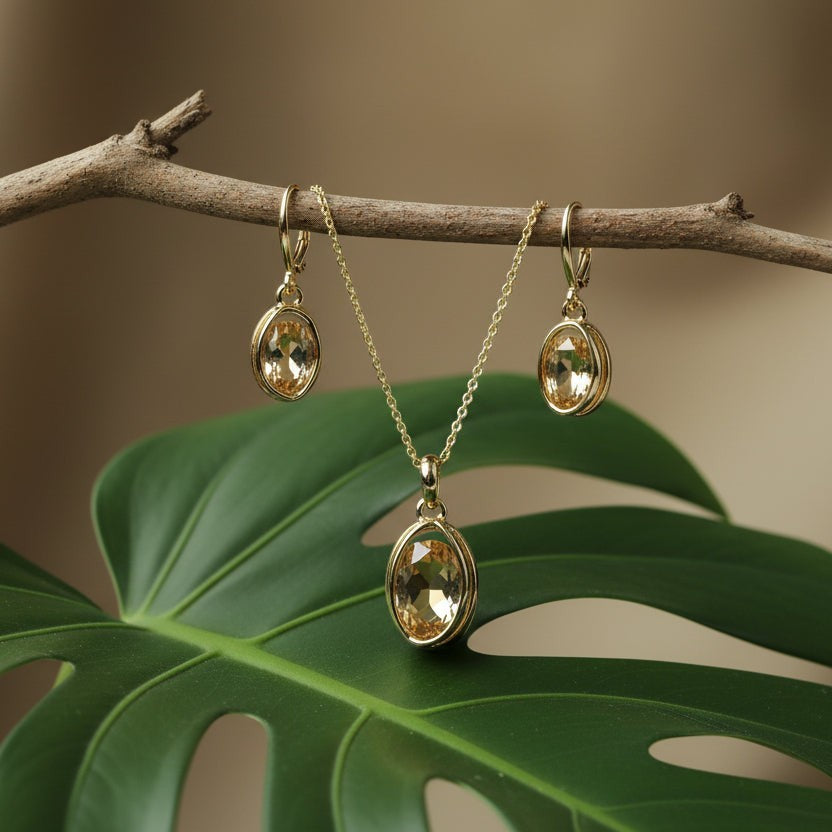 SVORA oval champagne crystal necklace and earrings set in polished gold with 18K gold tone plating.