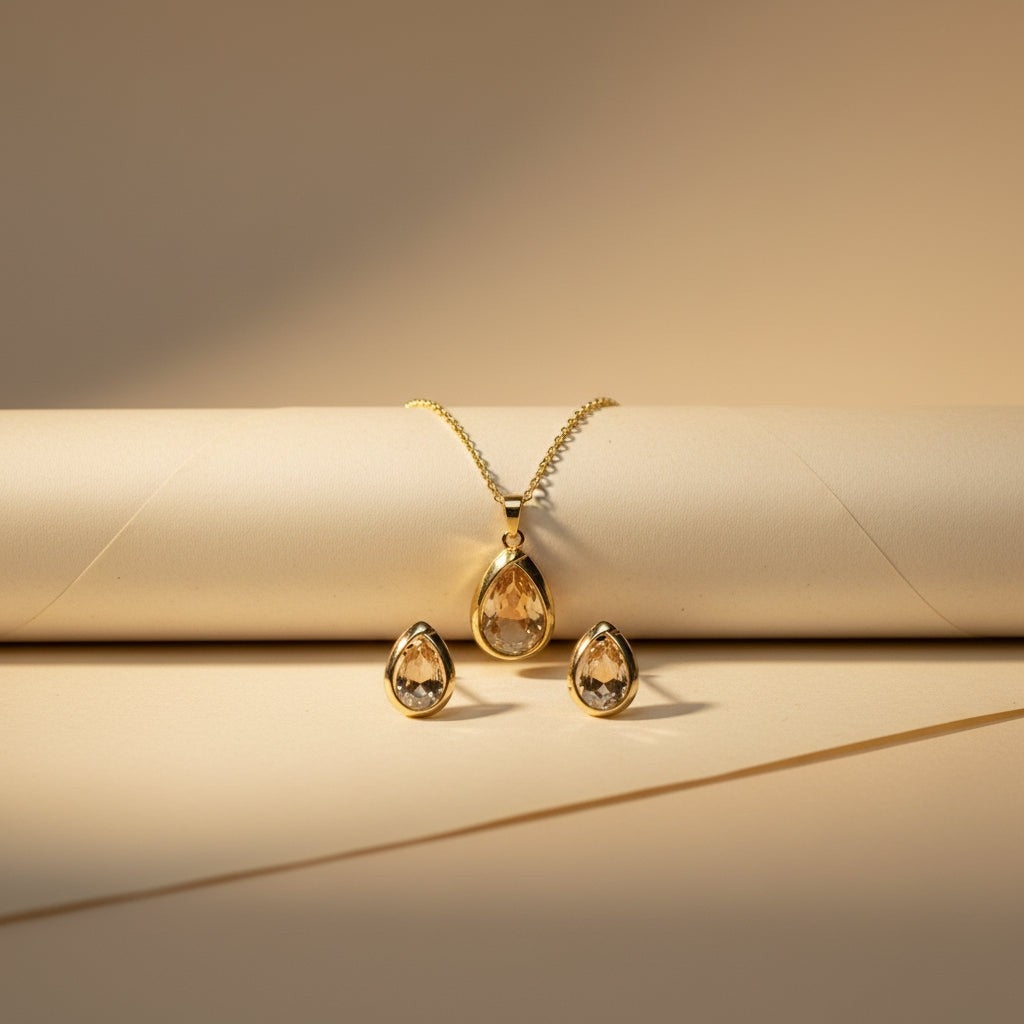 SVORA champagne pear-cut crystal necklace and matching earrings set in polished gold.