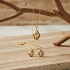 SVORA champagne pear-cut crystal necklace and earrings set in polished gold.