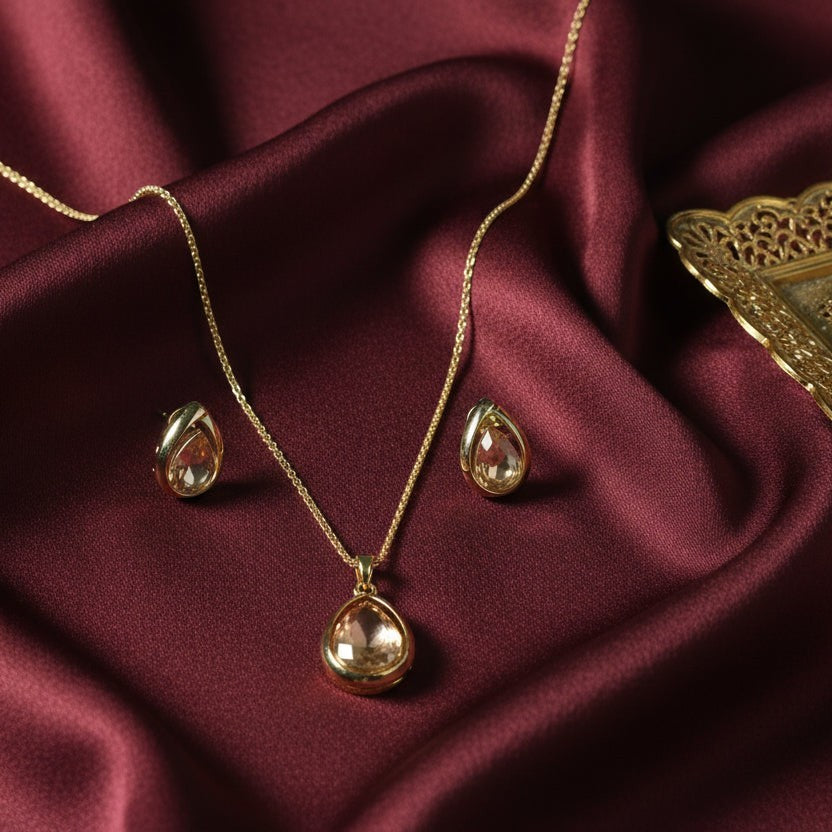 SVORA champagne pear-cut crystal necklace and earrings set in polished gold tone stainless steel.