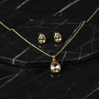 SVORA gold-tone stainless steel necklace and earrings set with champagne pear-cut crystals.