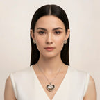 SVORA champagne crystal heart necklace and earrings set with silver bezels. Model wears a white dress.