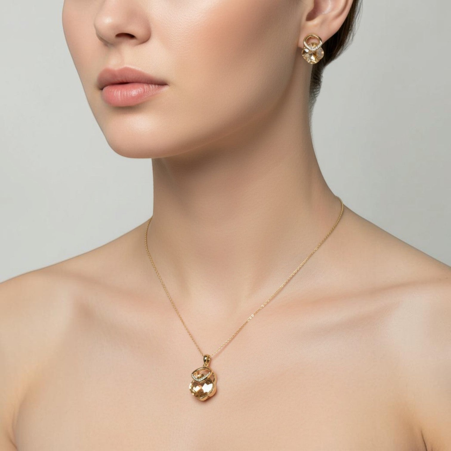 SVORA champagne crystal pendant necklace and matching earrings set with pavé detail, 18K gold tone.