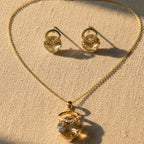 SVORA champagne crystal pendant necklace and matching earrings with pavé detail, 18K gold tone.
