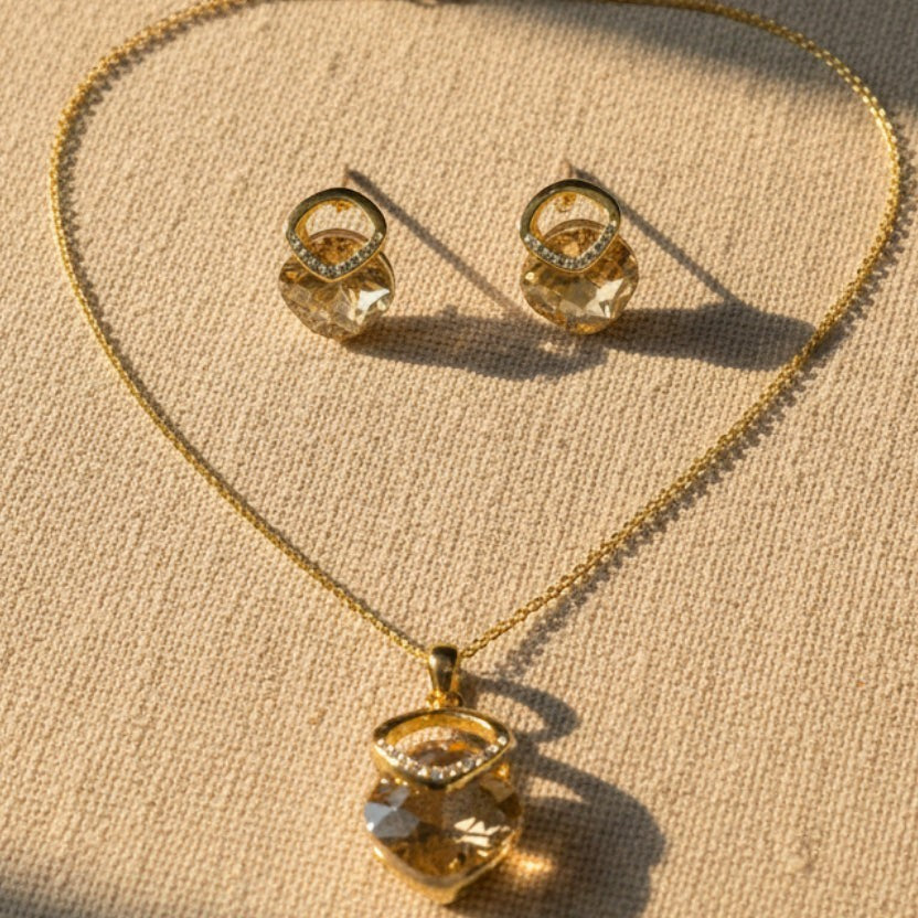 SVORA champagne crystal pendant necklace and matching earrings with pavé detail, 18K gold tone.