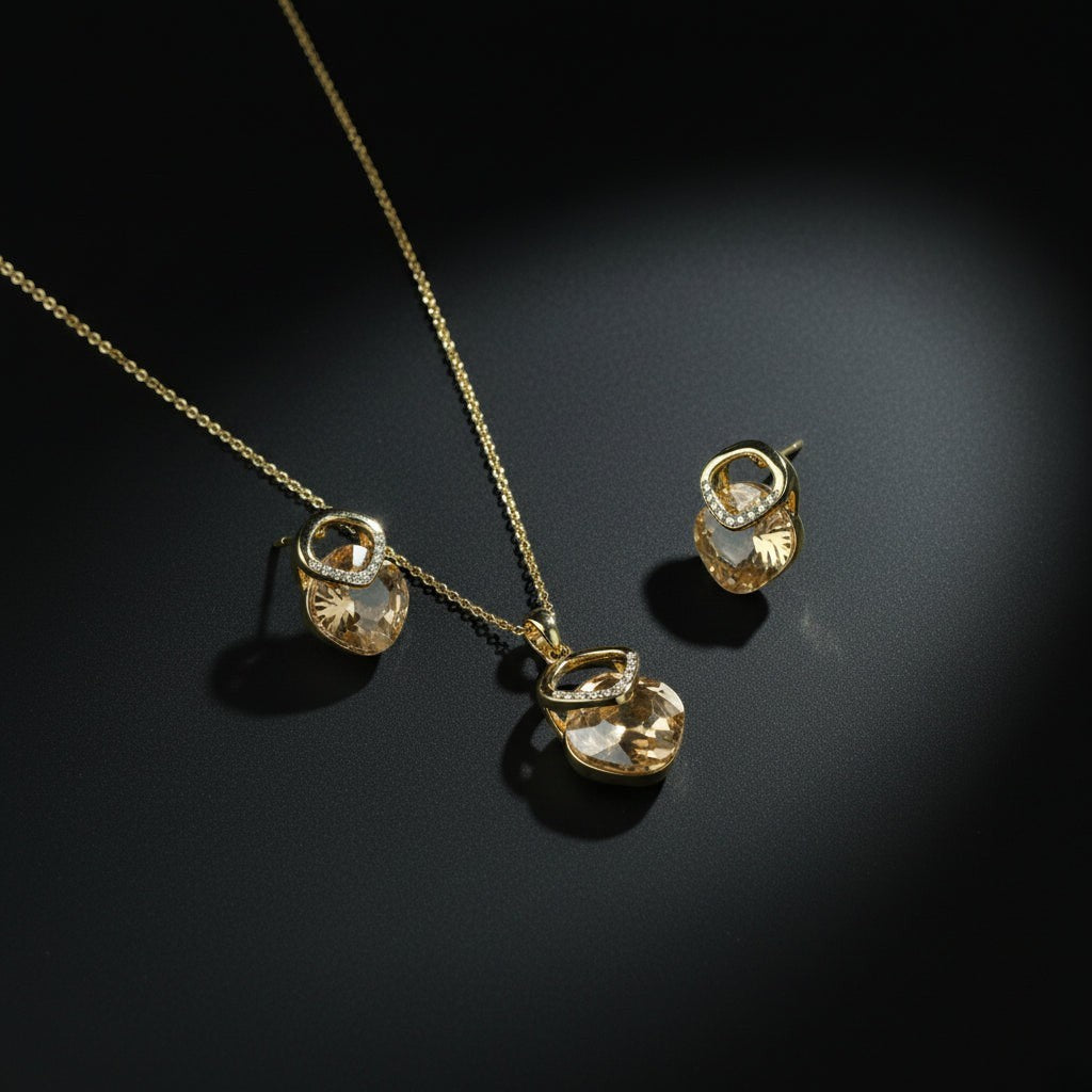 SVORA champagne crystal pendant necklace and matching earrings with pavé detail, 18K gold tone.
