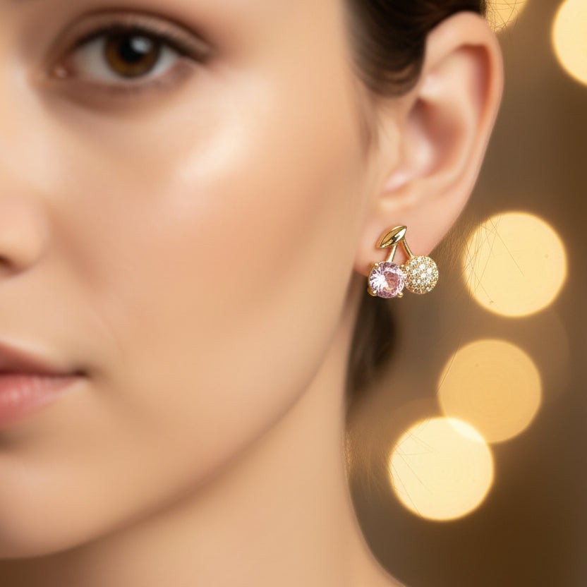 SVORA gold leaf stud earrings with pink crystal and pavé cherry charms. Stainless steel with 18K gold tone plating.