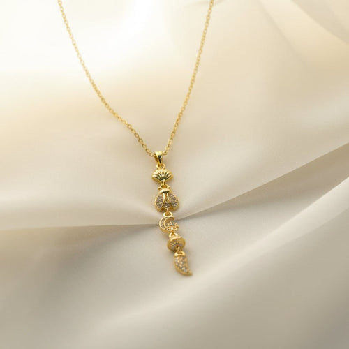 SVORA gold plated stainless steel lariat necklace with shell, bee, moon, heart, and leaf charms.