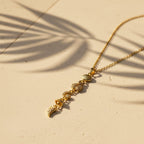 SVORA gold plated stainless steel lariat necklace with shell, bee, moon, heart, and leaf charms.