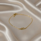 SVORA gold plated stainless steel bracelet with two connected hearts, one solid and one open. Adjustable.