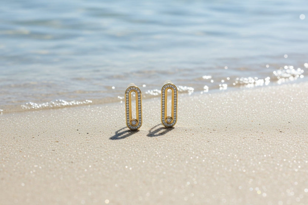 SVORA gold tone stainless steel dangle earrings with pavé cubic zirconia bars and a moving stone detail.